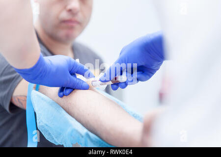 Praticien de laboratoire de l'extraction du sang d'un patient Banque D'Images