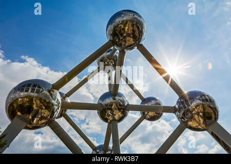 Grand art en acier inoxydable structure dans la forme d'un atome avec ciel bleu et soleil radié ; Bruxelles, Belgique Banque D'Images