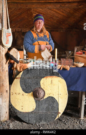 Reenactor en costume entouré par une variété d'articles fabriqués à la main qui aurait été normalement négociés lors de l'Anse aux Meadows a été colonisée par les Vikings vers l'an 1000. Norstead Village Viking et le port de commerce, DE L'Anse aux Meadows, Terre-Neuve, Canada Banque D'Images