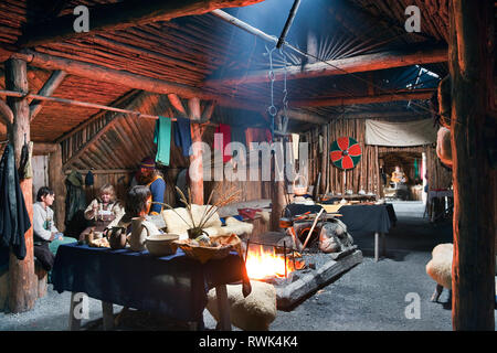 Reenactors en costumes d'effectuer des tâches traditionnelles à l'intérieur d'une maison longue Viking recréé à Norstead Village Viking et le port de commerce, DE L'Anse aux Meadows, Terre-Neuve, Canada Banque D'Images