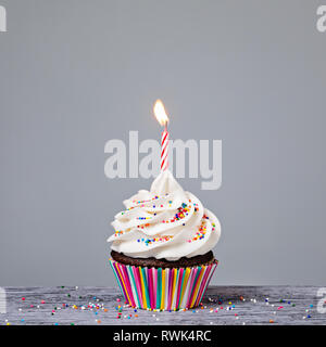 Birthday Cupcake avec une bougie rouge et coloré arrose Banque D'Images