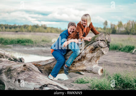 Mère fille mature avec une liaison à l'extérieur. Funny Horse Racing sur log. Week-end fun, Famille Banque D'Images