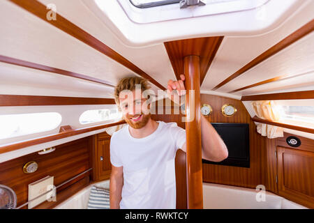 Jeune homme en voilier cabin, portrait Banque D'Images