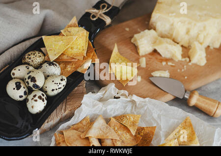 Des plaquettes de croustillant pain plat de fromage parmesan et oeufs de caille dans une assiette faites à partir de la bouteille. Snaks concept. Banque D'Images