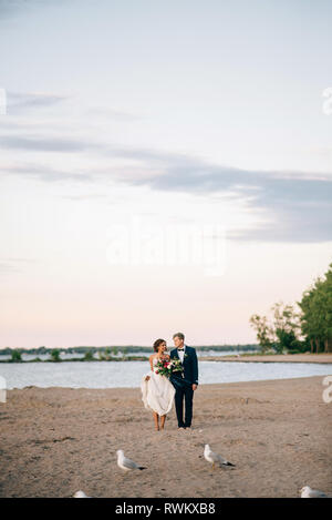 Mariée et le marié romantique au bord du lac, pieds nus sur le lac Ontario, Toronto, Canada Banque D'Images