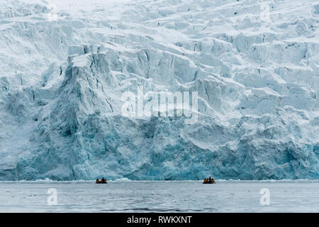 Les touristes sur les bateaux gonflables explorer calotte glacière, au nord du Spitzberg, Norvège Banque D'Images