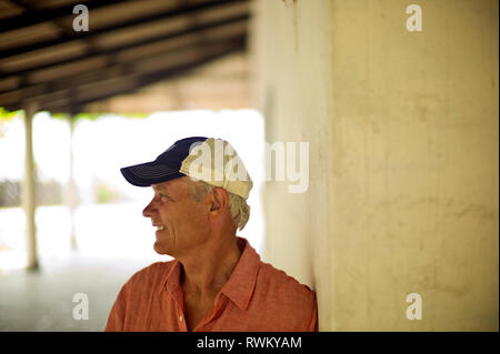 Homme mûr sourire alors qu'il regarde ailleurs alors qu'il pose pour un portrait. Banque D'Images