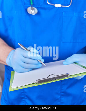 Médecin en uniforme bleu est titulaire d'un stylo et porte-papier dans sa main, selective focus Banque D'Images