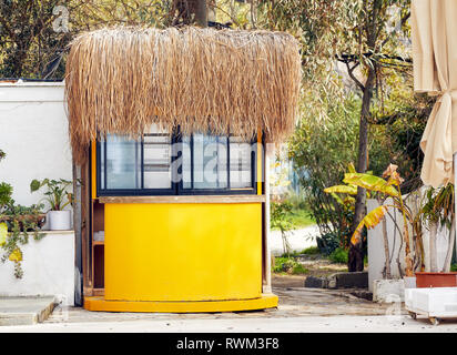 Charmante petite cabane jaune avec un toit de chaume dans un site de vacances tropicales Banque D'Images
