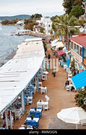 Vue aérienne de la station restaurants de poissons de gumusluk côte à Bodrum, Turquie et les gens qui marchent sur la route. Banque D'Images