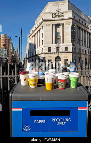 Papier et de plastique et les bouteilles en plastique tasses vide debout sur une poubelle de recyclage du papier que la station de métro Bank dans la ville de London UK KATHY DEWITT Banque D'Images