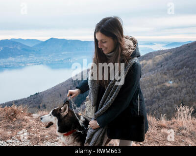 Woman walking dog sur colline, Premeno, Piémont, Italie Banque D'Images