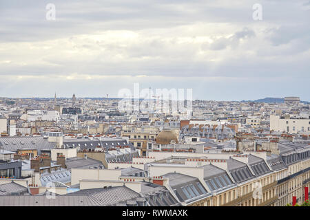 Vue sur les toits de Paris et sur les toits de la ville dans un jour nuageux avec sun beam en France Banque D'Images