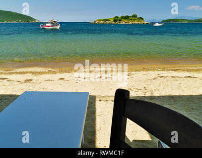 Vue d'une plage de sable avec des bateaux dans l'eau cristalline d'un restaurant à Kavala en Grèce. Banque D'Images