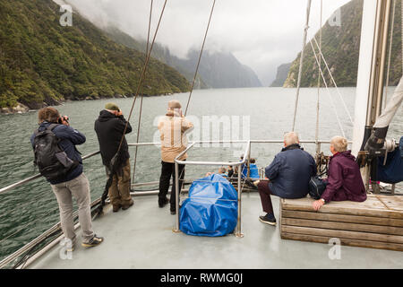 Les touristes dans un bateau à Milford Sound, Nouvelle Zélande Banque D'Images