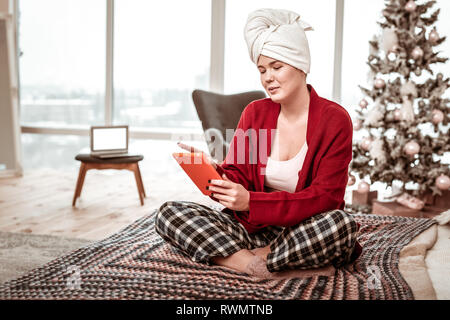 Intéressé en costume femme reposant home sitting on bed with tablet Banque D'Images