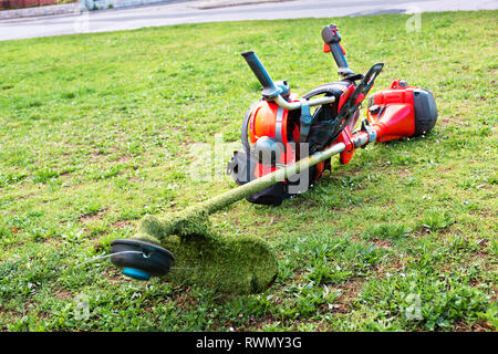 Coupe-herbe / débroussailleuse, casque de sécurité et autres équipements de mise sur la pelouse Banque D'Images