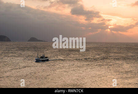 Bateau de pêche entrant pendant le coucher du soleil, vers le port d'Avilés, dans les Asturies, Espagne Banque D'Images