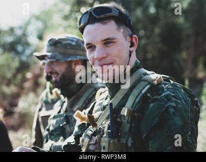 Joueur de jeu militaire Airsoft des uniformes de camouflage avec Armed Assault Rifle. Banque D'Images