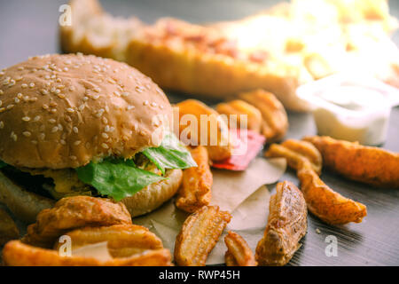 Hamburger, frites deluxe, pizza, fromage, laitue et sauce à la crème aigre. Restauration rapide Banque D'Images