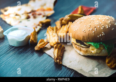 Hamburger, frites deluxe, pizza, fromage, laitue et sauce à la crème aigre. Restauration rapide Banque D'Images