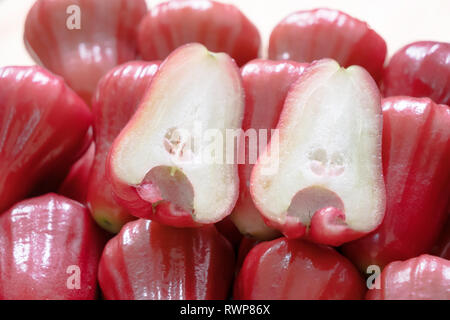 Syzygium est un genre de plantes à fleurs. Qui peut être mangé. Fermer la moitié rose pomme sur le tas. Banque D'Images