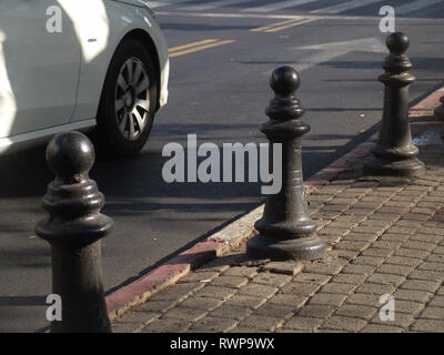 Urban street view d'une voiture blanche de la conduite sur la route avec une composition en diagonale et point de vue sur le trottoir en plein jour. Banque D'Images