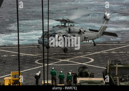 190215-M-QP663-00012 OCÉAN PACIFIQUE (fév. 15, 2019) Un Sea Hawk MH-60S avec l'Escadron d'hélicoptères de combat de la mer 21 atterrit sur le pont d'envol du Harpers Ferry-class amphibious landing ship dock USS Harpers Ferry (LSD 49), au cours des opérations de routine dans le cadre du groupe amphibie Boxer dans l'océan Pacifique. (U.S. Marine Corps photo par le Cpl. Adam) Dublinske Banque D'Images