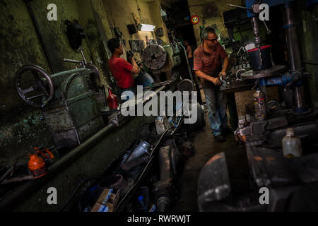 Les travaux sur la mécanique automobile colombien tours métalliques dans un atelier de réparation de voiture dans la région de Barrio Triste, Medellín, Colombie. Banque D'Images