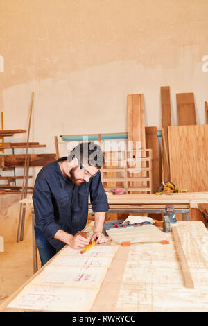 Jeune artisan dans son atelier ou à l'architecte dessine un plan directeur Banque D'Images