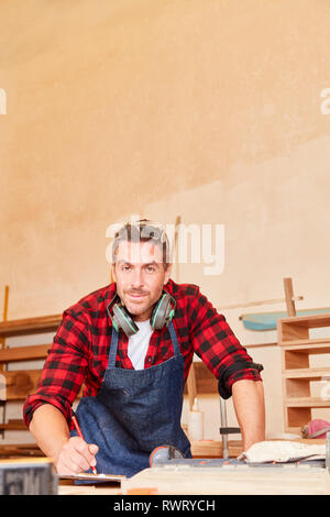 L'homme en tant qu'une autorité ou carpenter avec liste de contrôle dans l'atelier Banque D'Images