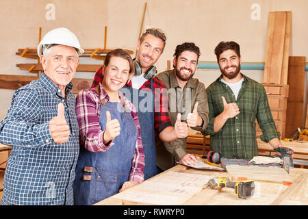 L'équipe avec succès artisan Thumbs up dans l'atelier de menuiserie Banque D'Images