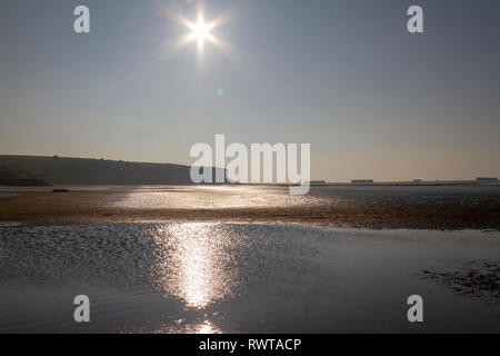 Vue sur la plage à marée basse par un beau soir de l'Arromanches-les-Bains plage au coucher du soleil, Normandie, France. Banque D'Images