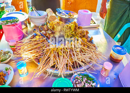 La préparation des abats de porc savoureux en sauce épicée à l'étal de nourriture juste au cours de célébration du Nouvel An Chinois, Yangon, Myanmar. Banque D'Images