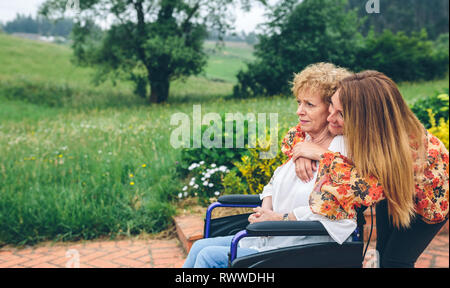 Hauts femme dans un fauteuil roulant avec sa fille Banque D'Images