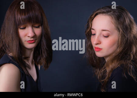 Portrait de groupe de deux filles sur fond sombre Banque D'Images