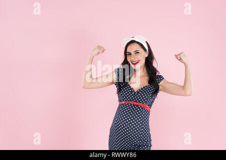 Happy pregnant woman in dress montrant oui geste isolé sur pink Banque D'Images