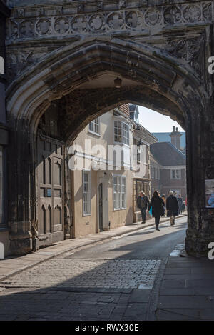 Salisbury, Wiltshire, Angleterre, Royaume-Uni. Mars 2019. Visiteurs en passant par la porte nord de la cathédrale de la ville en direction de la Grand-rue Fermer Banque D'Images