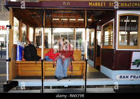 La vue classique du câble traditionnel historique voitures rouler sur la célèbre rue de la Californie dans la belle lumière du matin au lever du soleil en été, San Francisco, États-Unis Banque D'Images