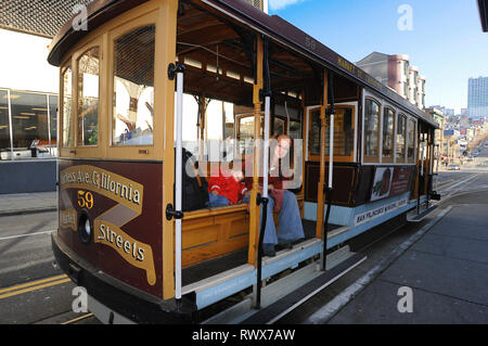 La vue classique du câble traditionnel historique voitures rouler sur la célèbre rue de la Californie dans la belle lumière du matin au lever du soleil en été, San Francisco, États-Unis Banque D'Images