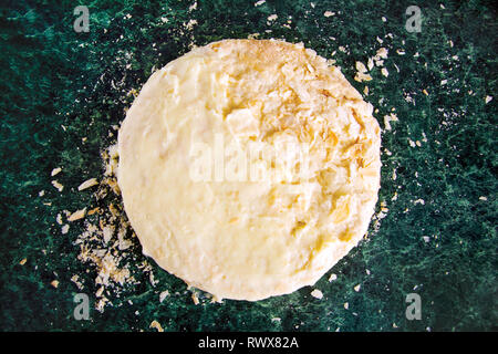 Gâteau rond Napoléon en couches avec de la crème anglaise et saupoudré des miettes sur une table de marbre vert, vue du dessus. Le processus de recette de cuisine, desserts. Banque D'Images