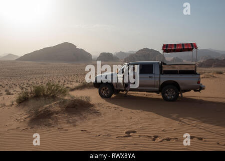 WADI RUM, JORDANIE - Mai 18, 2018 : guide bédouin Local descendre de son 4x4 dans le désert dans un lieu sunset view Banque D'Images