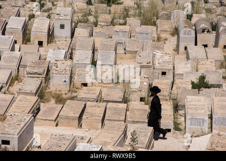 Jérusalem, Israël - 16 MAI 2018 : l'homme Juif Haredi de marcher à travers les pierres tombales dans le cimetière juif du Mont des Oliviers Banque D'Images