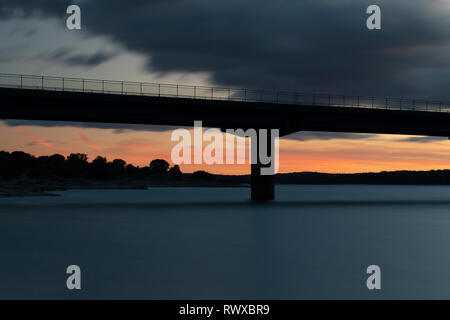 Coucher de soleil après une traversée du viaduc au-dessus d'un lac Banque D'Images