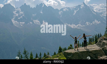 Les femelles les randonneurs de profiter de la vue sur les montagnes et les planeurs para sur la vallée de Chamonix, en France et en direction du Mont Blanc dans les Alpes françaises. Banque D'Images