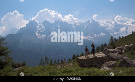 Les femelles les randonneurs de profiter de la vue sur les montagnes et les planeurs para sur la vallée de Chamonix, en France et en direction du Mont Blanc dans les Alpes françaises. Banque D'Images