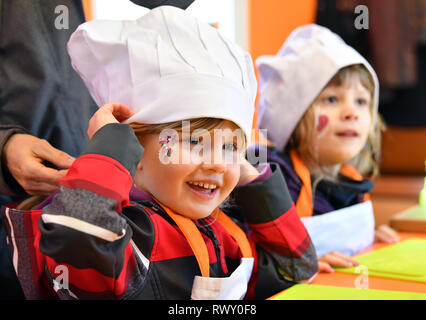 Erfurt, Allemagne. 07Th Mar, 2019. Un enfant de la maternelle à Erfurt Johannesplatz met sur un chapeau de chef au cours de la présentation de 'Julchens Kinderplanet Kochmobil' par la fondation. La cuisine mobile est équipé d'une cuisine de ménage et une surface de travail, où les enfants peuvent préparer leur propre nourriture sous la direction d'un cuisinier. Crédit : Martin Schutt/dpa-Zentralbild/dpa/Alamy Live News Banque D'Images