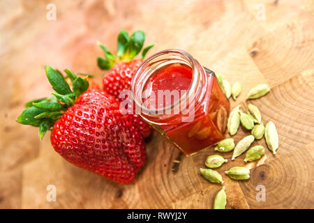 Dans un pot de confiture de fraises sur fond de bois Banque D'Images