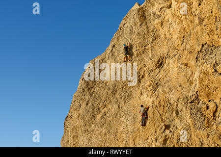 Deux hommes sont à l'escalade sur les cordes d'assurage mur vertical d'Alchak la montagne du cap à Sudak, Crimée, la Russie. Banque D'Images