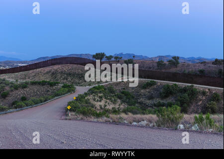 US Border Fence à travers collines, au crépuscule, à la recherche du sud à l'ouest de Port d'entrée, Mariposa Nogales, Arizona, Avril 2018 Banque D'Images